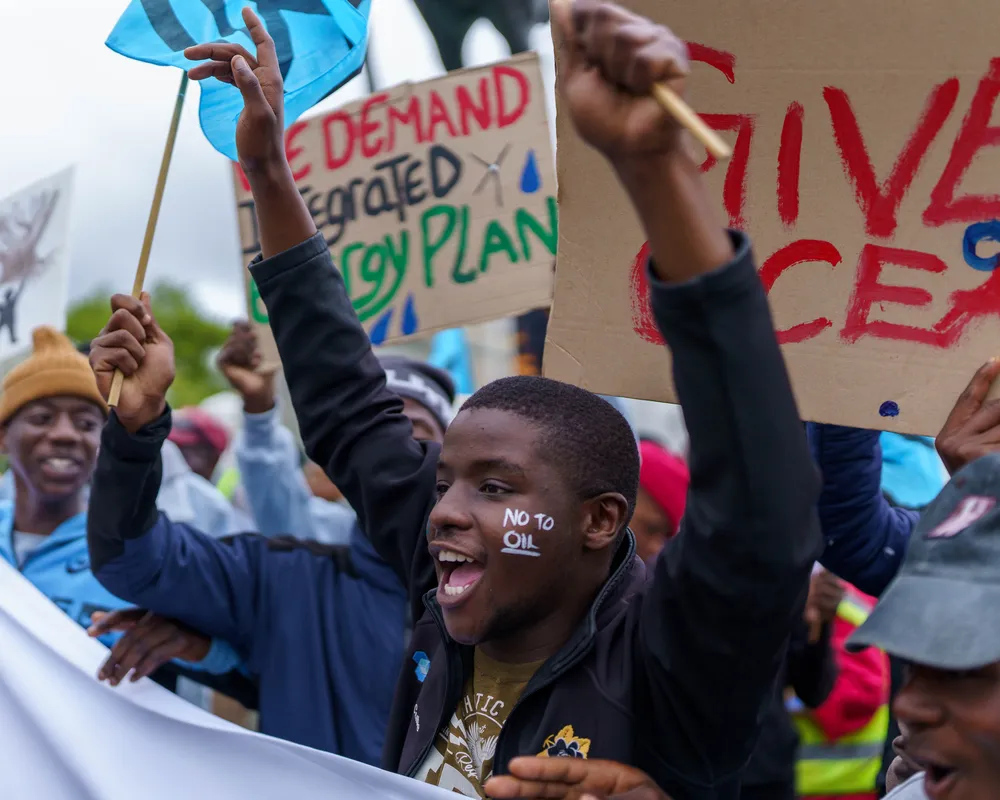 A boy with a no to oil sign on face protesting