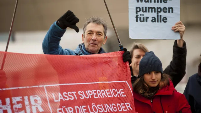 Aktivist*innen halten einen Banner mit 'Lasst Superreiche für die Lösungen der Klimakrise zahlen".