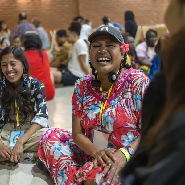 Two participants laughing as they sit in circle during a workshop.