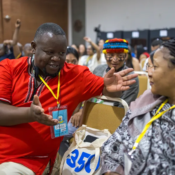 Two gathering participants sitting next to each other and discussing.