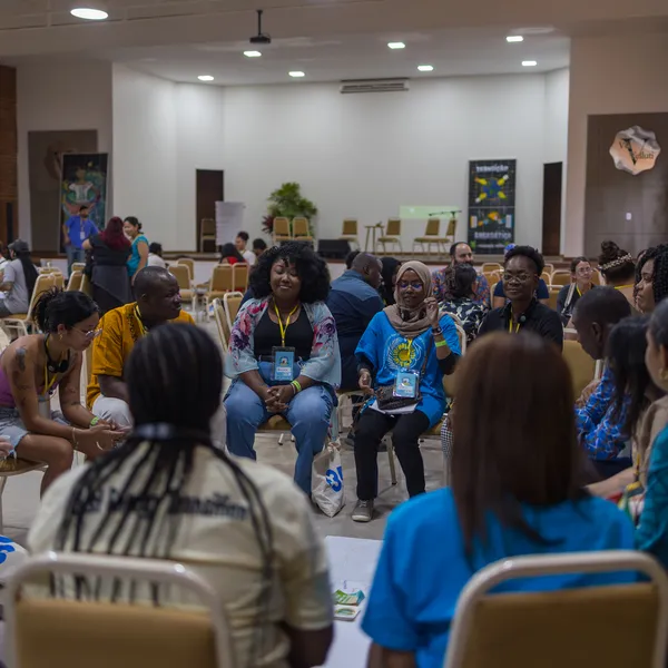 A diverse group of activists seated in different circles discussing during a workshop.