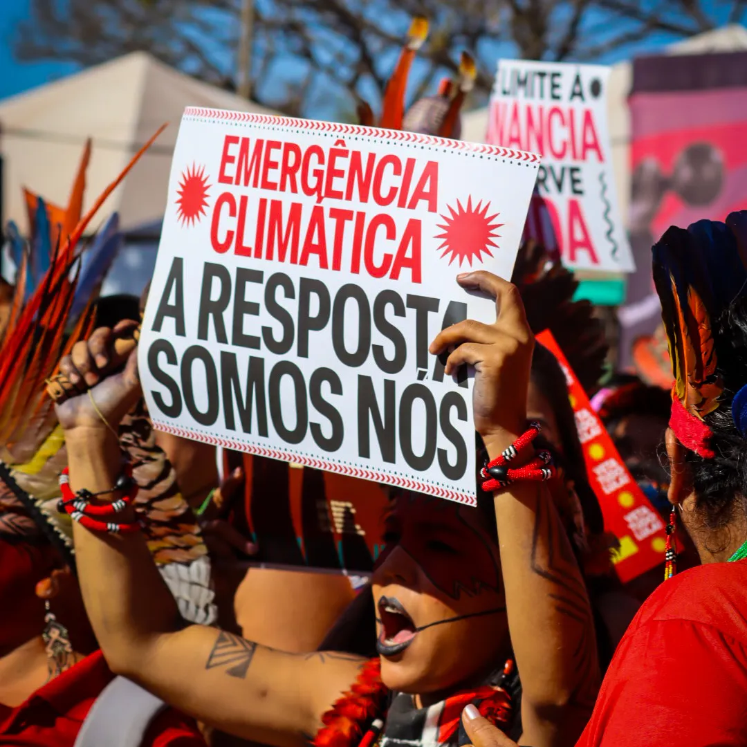 Mulher segura cartaz com o dizer Emergência Climática A resposta somos nós