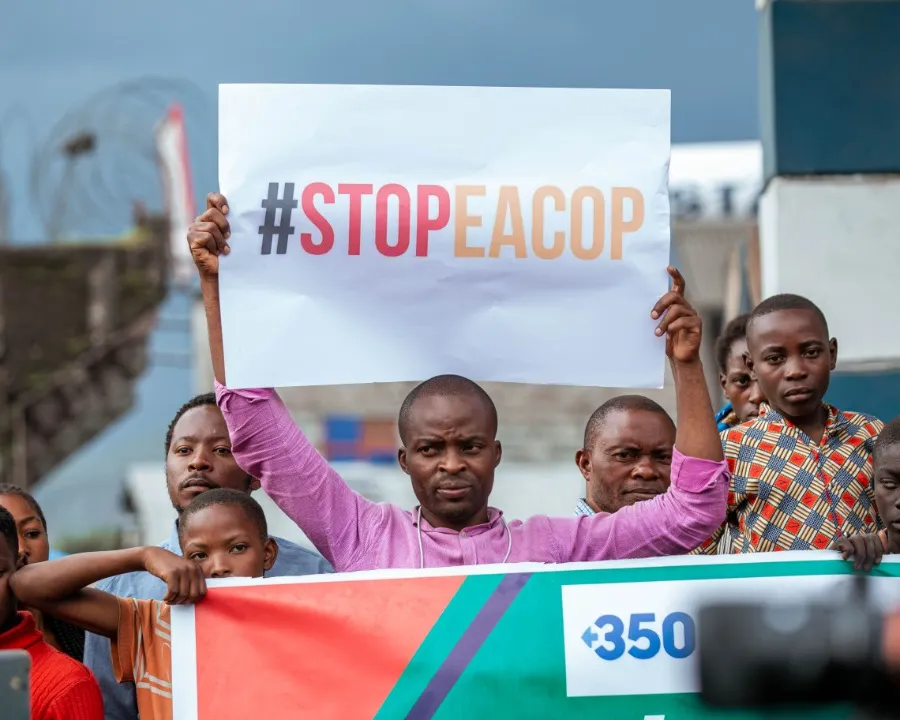 Protestors hold a StopEACOP sign