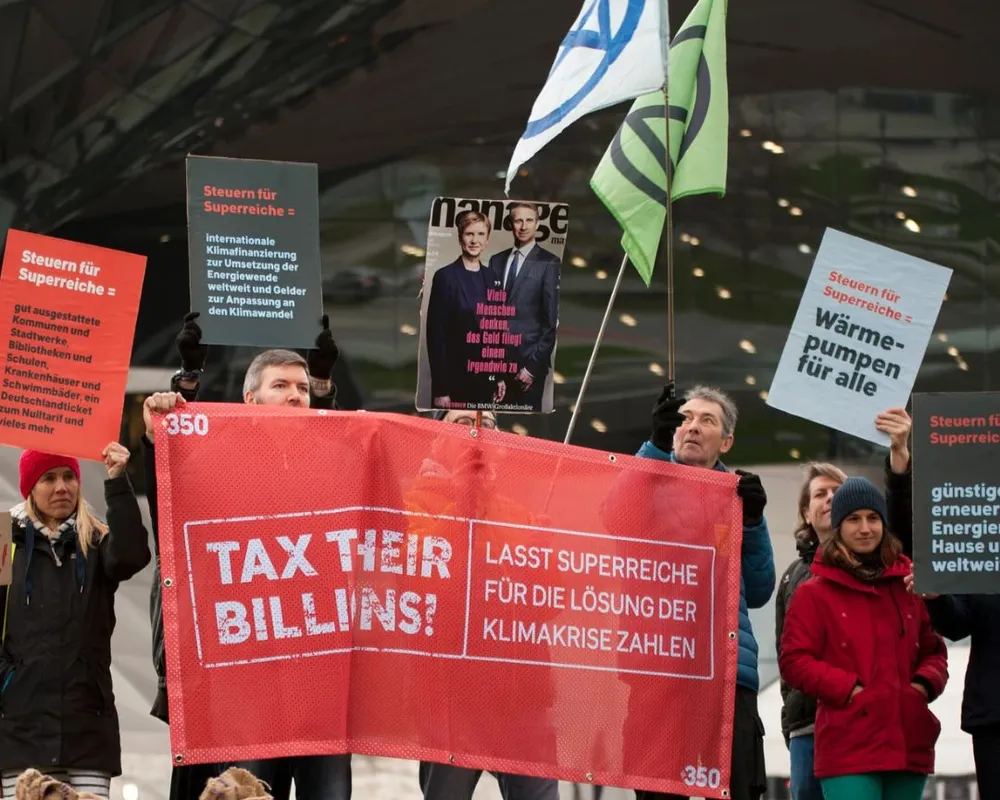 People take action in Germany with 350's Tax Their Billions campaign, calling for wealth taxes on the super-rich to fund climate action and more.