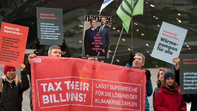 People take action in Germany with 350's Tax Their Billions campaign, calling for wealth taxes on the super-rich to fund climate action and more.