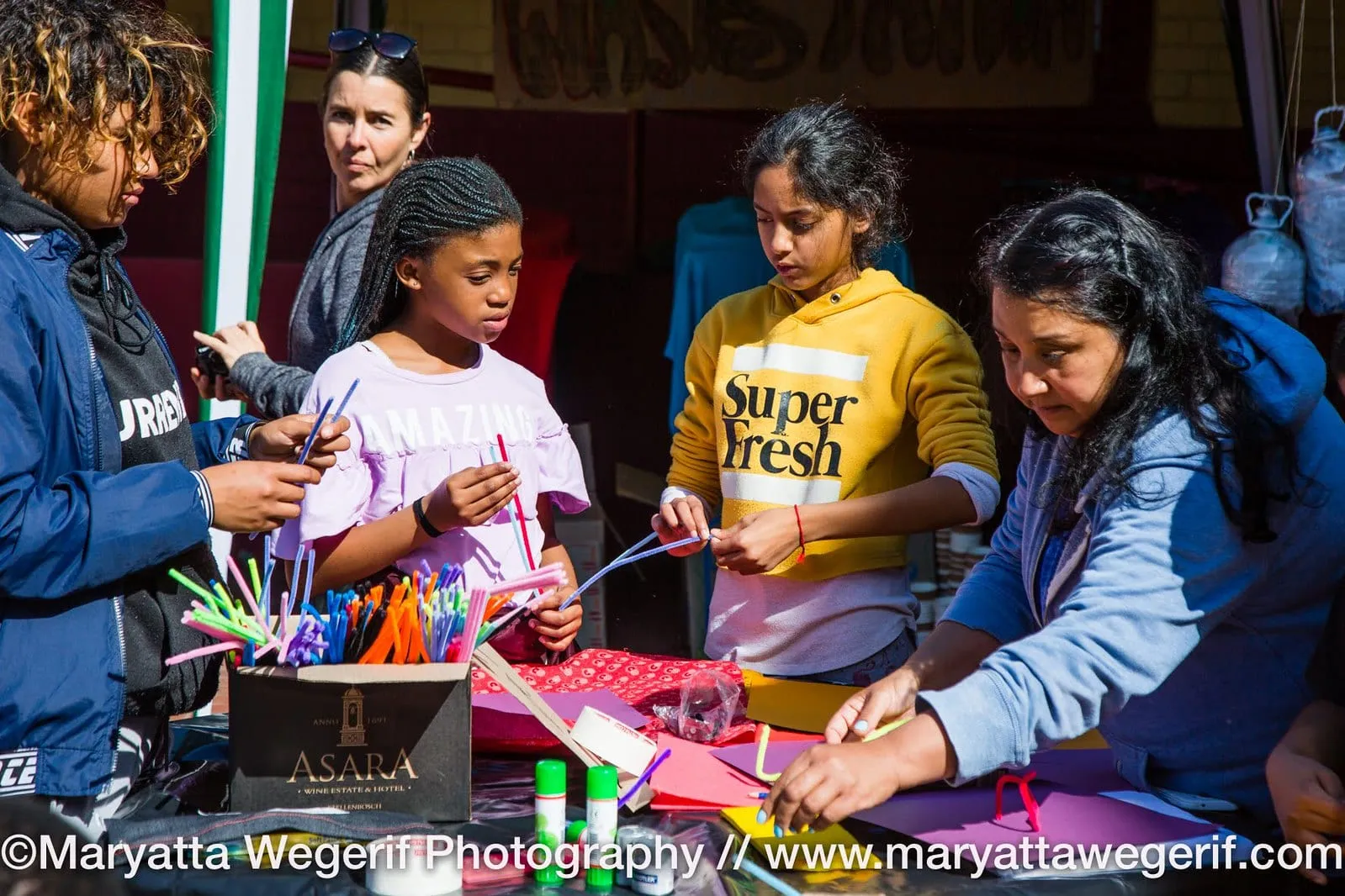 Teenagers at a table of crafts choosing art supplies
