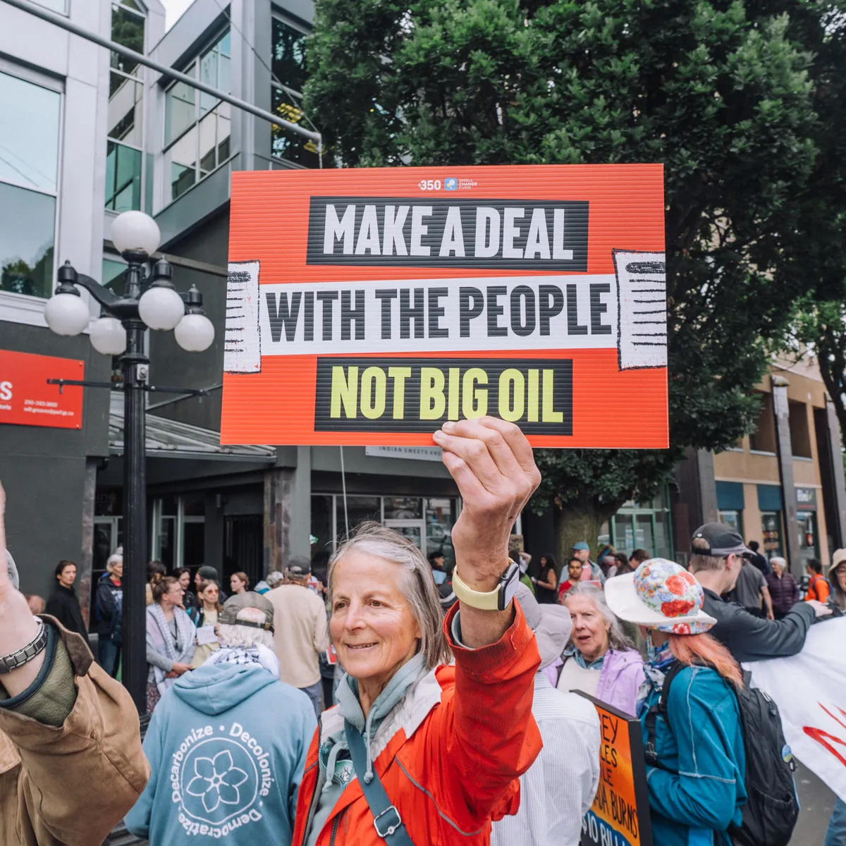 Demonstrator with a sign that reads "Make a Deal with the People not Big Oil"