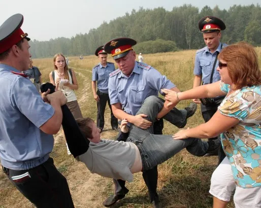 Policemen detain a member of the movement for the protection of Khimki forest for attempting to reach the site of its deforestation, outside Moscow on August 2, 2010. REUTERS/Alexander Natruskin