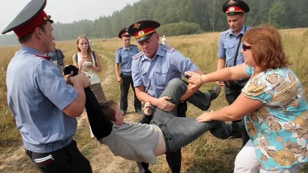 Policemen detain a member of the movement for the protection of Khimki forest for attempting to reach the site of its deforestation, outside Moscow on August 2, 2010. REUTERS/Alexander Natruskin