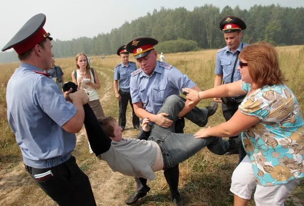 Policemen detain a member of the movement for the protection of Khimki forest for attempting to reach the site of its deforestation, outside Moscow on August 2, 2010. REUTERS/Alexander Natruskin