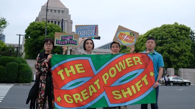 Activists stand in front of a building holding a banner.