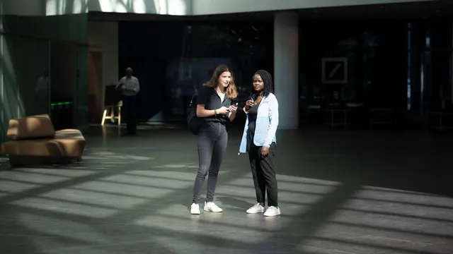 Luisa Neubauer und Evelyn Acham stehen in der Zentrale der Deutschen Bank