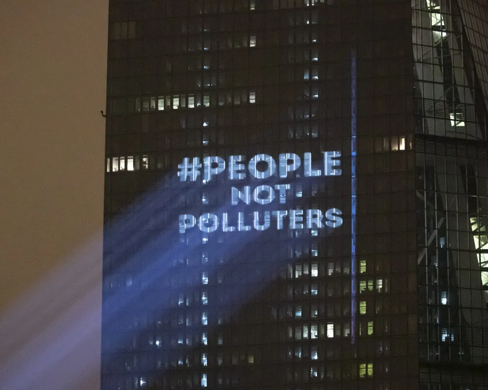 The Koala Kollectiv projected "People not Polluters" onto the side of the European Central Bank