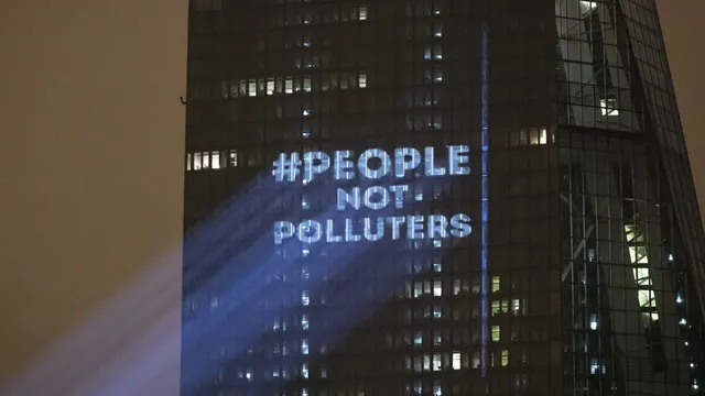 The Koala Kollectiv projected "People not Polluters" onto the side of the European Central Bank