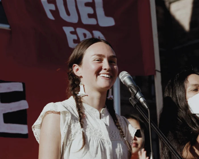 Activist smiling in front of microphone during protest.