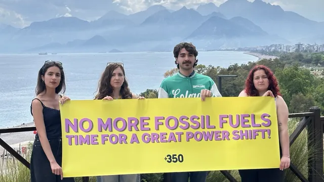 People standing with a banner in from of a lake.