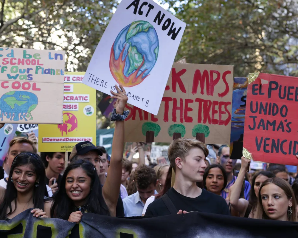 crowd of climate strike protesters holding banners