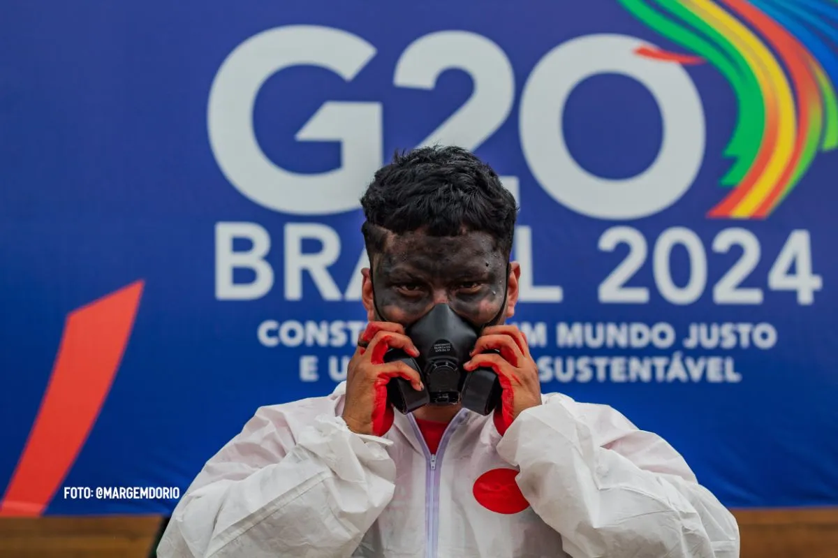 foto de homem usando máscara em frente ao banner do g20