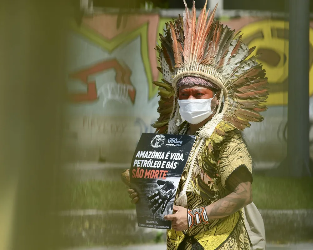 Ninawa Huni Kui in front of the Fossil Auction Event protesting for Amazon lands