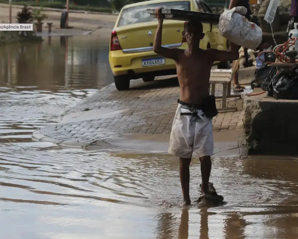 Morador cruza área alagada no Rio: enchentes cada vez mais graves são uma das faces mais visíveis da injustiça climática