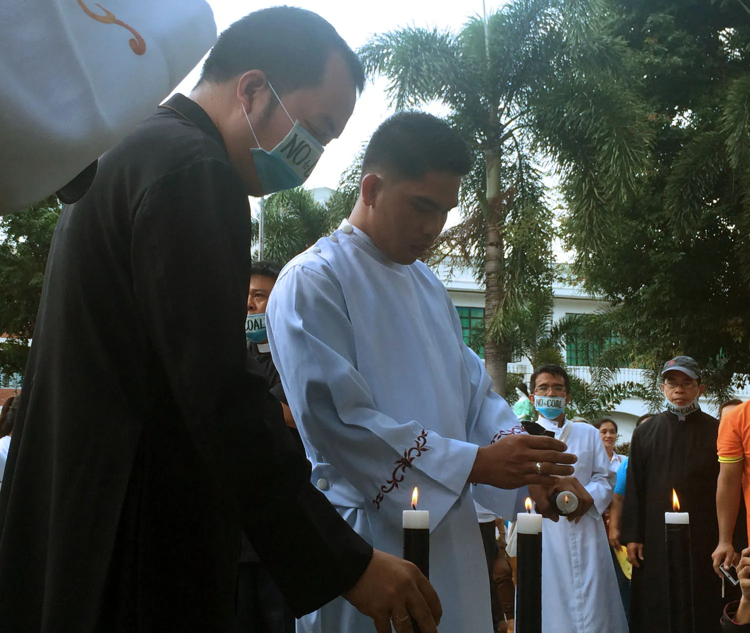Ministers lighting candles in front of the governor's palace. Photo: Chuck Baclagon