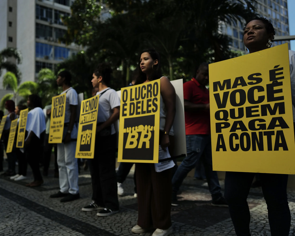 Homens e mulheres protestam em frente à Petrobras que anuncia lucro bilionário