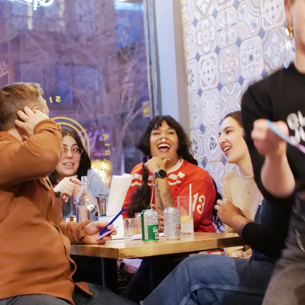 People sitting around a table laughing together.