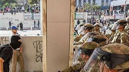 Protestors_with_CA_National_Guard_June_2025-e1749828649426.jpg
