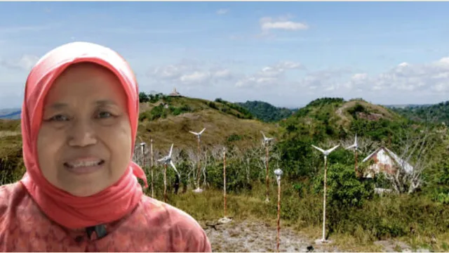 Local woman in front of small scale windmills.