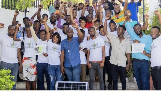 Activists standing together with a solar panel.