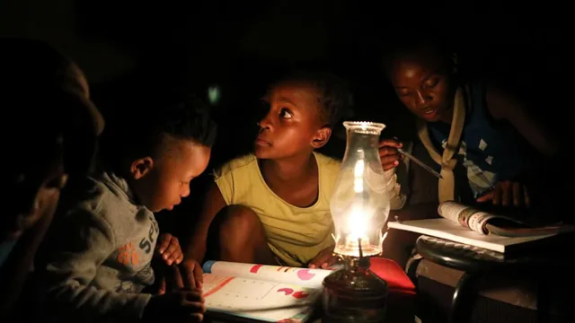 Kids studying with a lamp