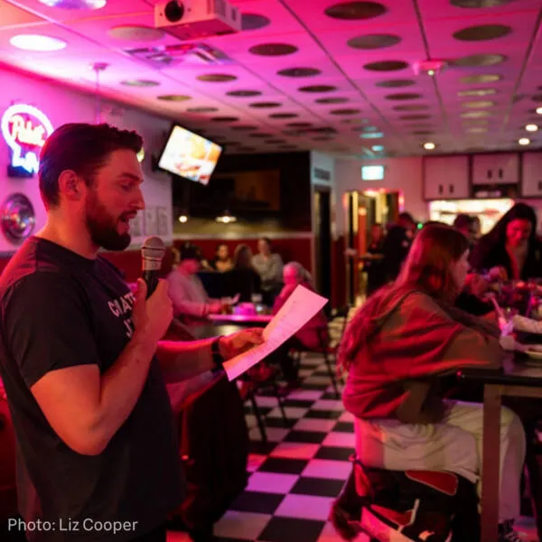 Toxic Trivia game night - person reading from a sheet of paper