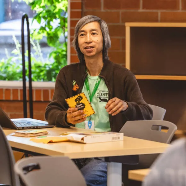 Toxic Trivia game day - person sitting a table holding a card