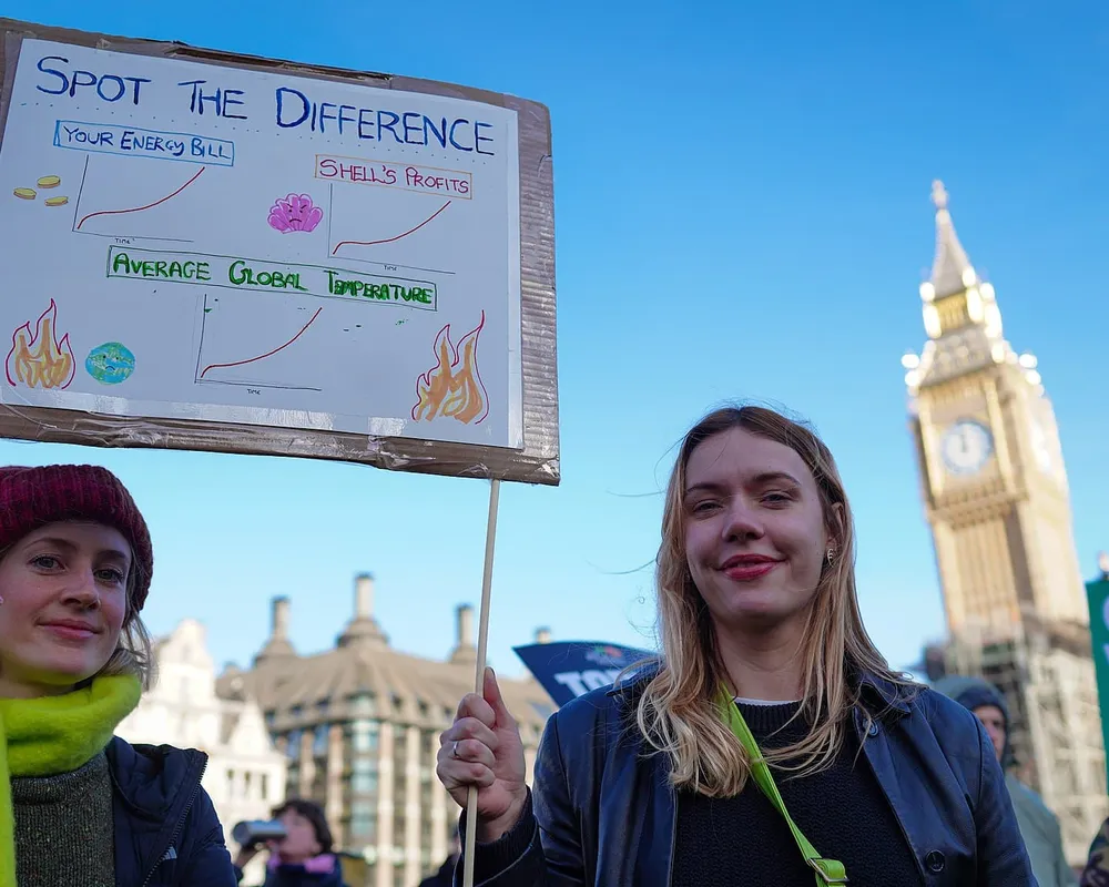 Two activists holding up placard with message relating to the cost of living crisis