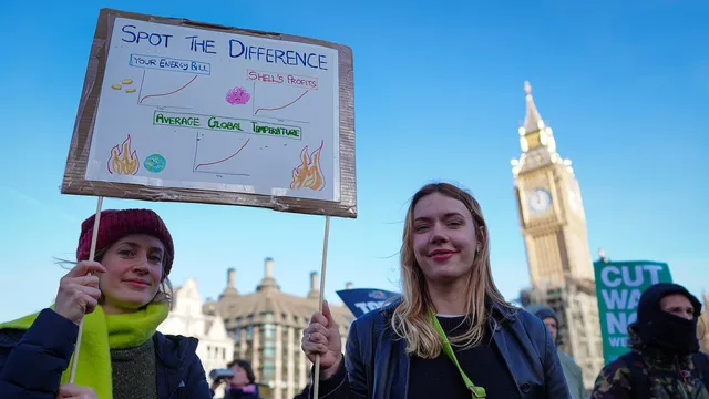 Two activists holding up placard with message relating to the cost of living crisis