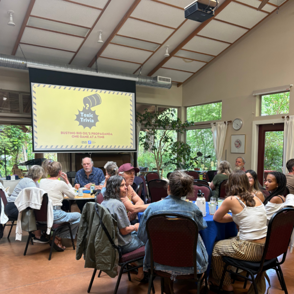 Toxic Trivia game day people sitting at tables playing watching a large projection screen