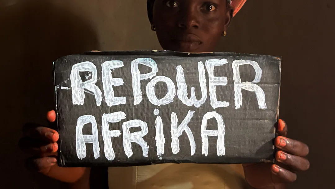 Portrait of a young activist holding a Repower Afrika sign.