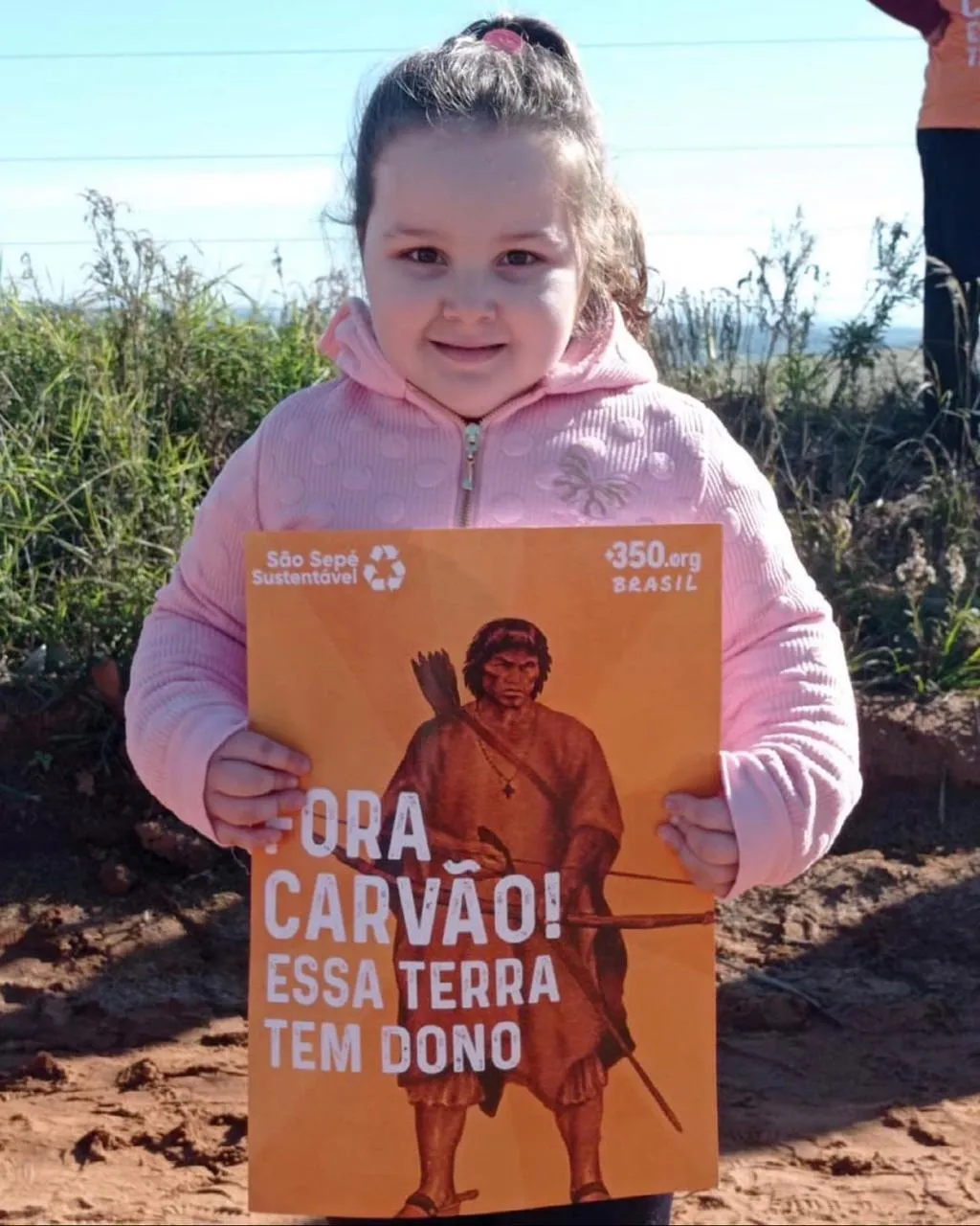 little girl holding plaque saying no to coal
