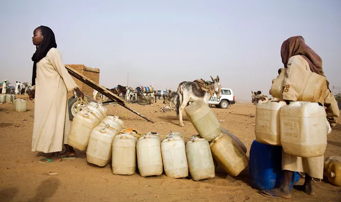 12 May 2010. Abu Shouk: Water point in Abu Shouk IDP Camp. 84.000 people collect water everyday from the only water point in the area. Each family has de right to collect water twice per week with, as maximum, 15 recipients of 8 liters each. They pay only 10 recipients and they get other 5 for free. Basically in the morning, mothers and children spend hours on the queue and, then, after filling the recipients, they bring them to their homes (some kilometers away) usually by donkeys or just walking. Photo by Albert Gonzalez Farran / Unamid