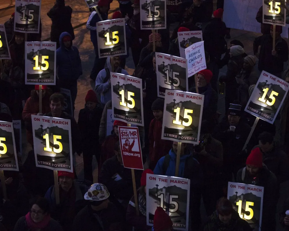 Demonstrators rally to raise the hourly minimum wage to $15 for fast-food workers at City Hall in Seattle