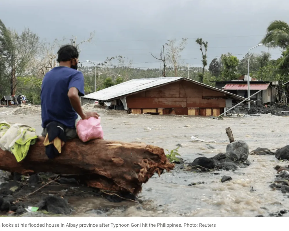 A man looking at his submerged house in Albay, Philippines