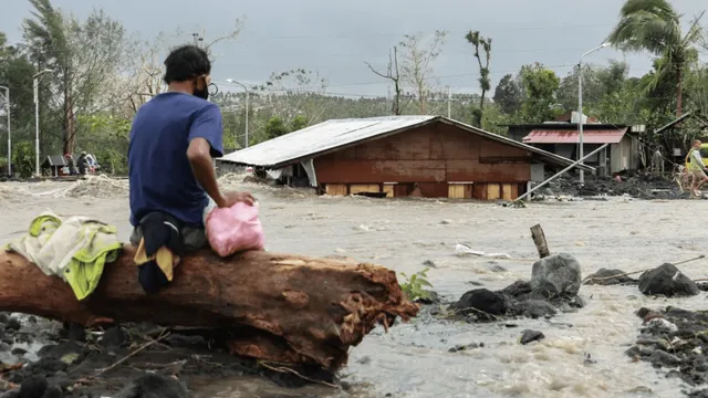 A man looking at his submerged house in Albay, Philippines