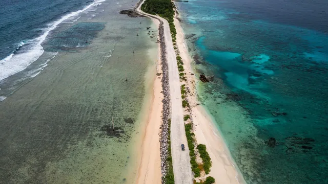 view from above of a road surrounded by the ocean on both sides