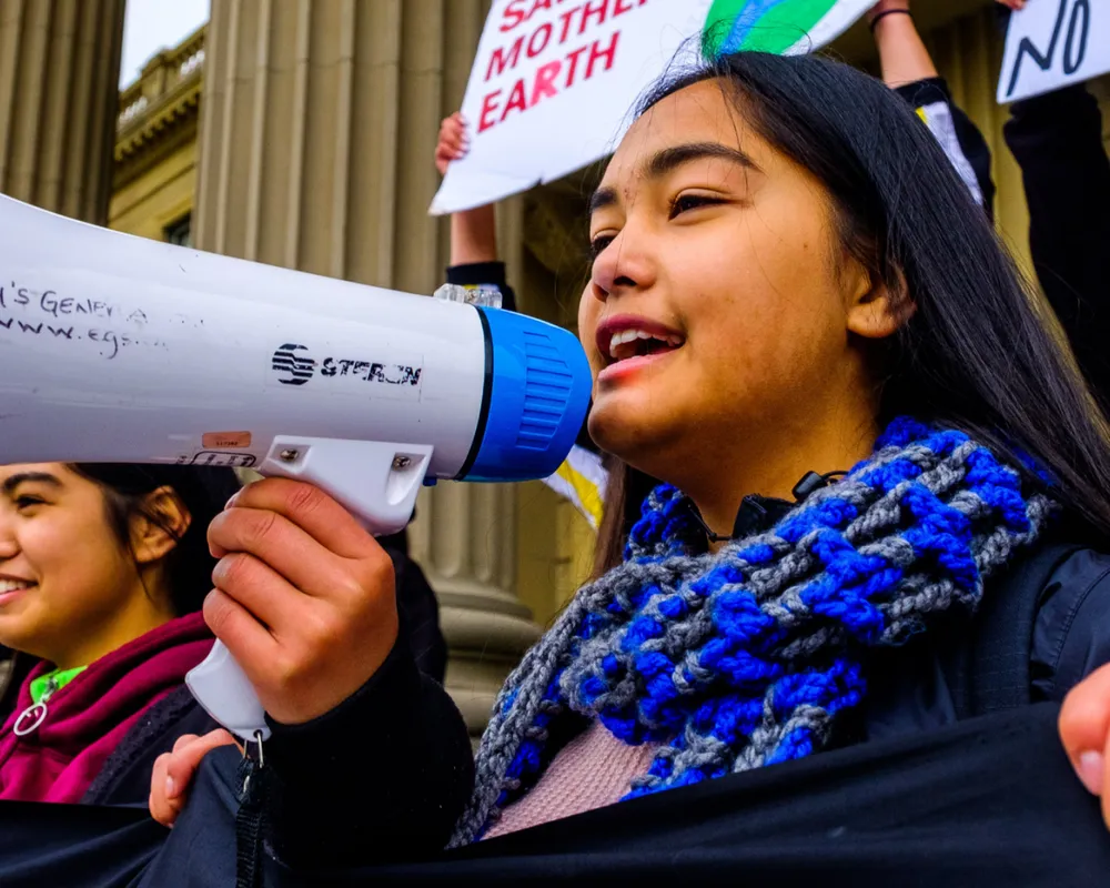 Activists speaking into megaphone during an action.