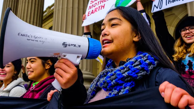 Activists speaking into megaphone during an action.