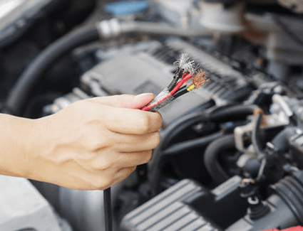 A person holds frayed wires.