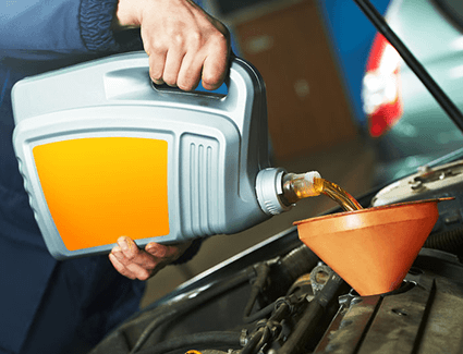 Person pouring oil into engine