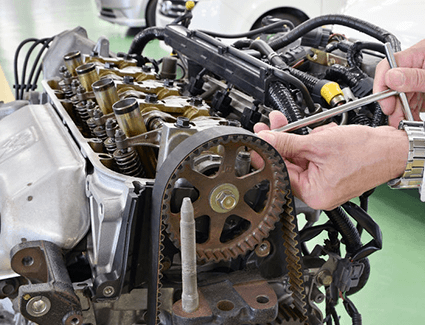This technician makes an adjustment to the engine's timing system