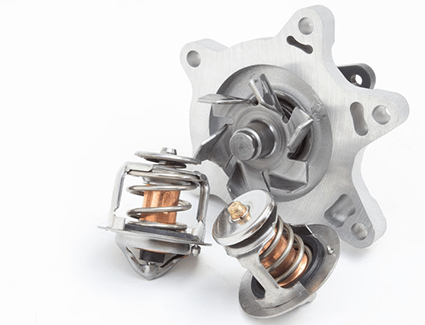 A pair of thermostats and a new water pump are on display against a white background