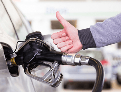 A driver gives us the thumbs up as he puts fuel in his vehicle.